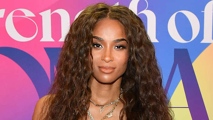 Ciara poses in a series of gold chain necklaces and sports her brown hair in a soft curl.
